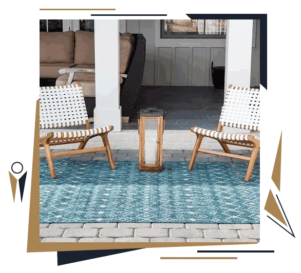 Blue outdoor carpet rug placed between woven patio chairs on a covered terrace