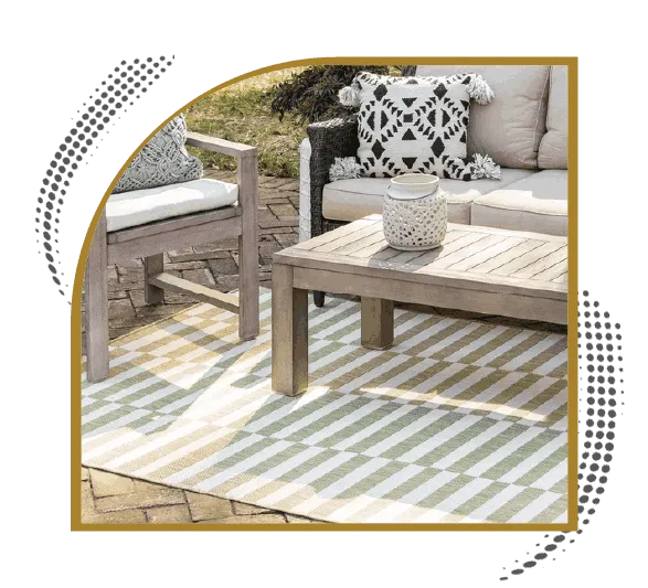 Green indoor outdoor rug beneath wooden patio furniture in a garden seating area