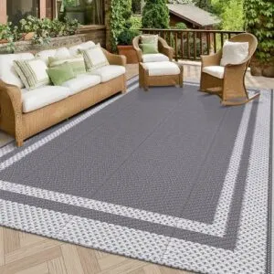 Large grey outdoor rug beneath wicker patio furniture in a garden seating area in Dubai